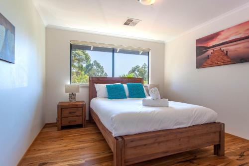 a bedroom with a large bed and a window at Shumadia I Private Properties in Yallingup Siding