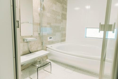 y baño con bañera, aseo y lavamanos. en Tokuto"King Villa" - Vacation STAY 73553v en Ieura