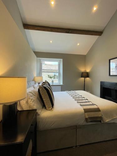 Un dormitorio con una cama grande con almohadas. en Queen's Cottage, Skipton, en Skipton