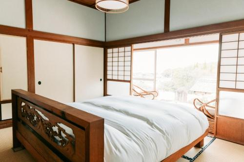 1 dormitorio con cama grande y ventana grande en Tokuto"King Villa" - Vacation STAY 73553v en Ieura