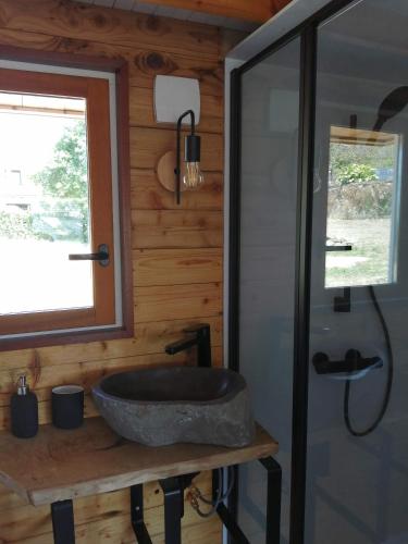 a bathroom with a stone sink and a window at La Tiny de Jeff in Uzel