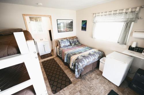 a small bedroom with a bed and a window at Cabin 3 Lynn View Lodge in Haines