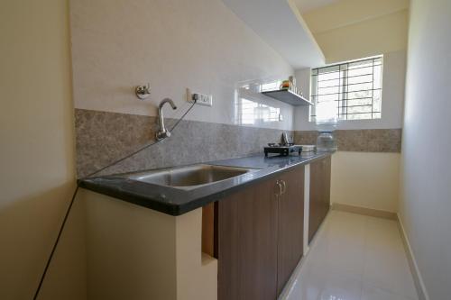 eine Küche mit einer Spüle und einer Arbeitsplatte in der Unterkunft HomeSlice Sarjapur - 1BHK Serviced Apartment in Bangalore