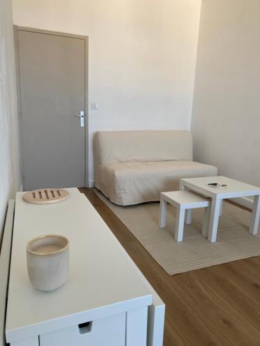 a room with a bed and tables in it at Studio moderne avec vue mer - Pietranera - Proche Bastia in Pietranera