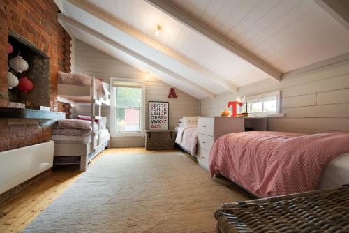 1 dormitorio con 2 camas y pared de ladrillo en Morgantis en Daylesford