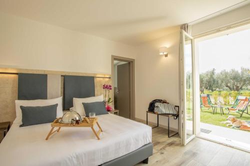 Riva Toscana Golf Resort & SPA في فولونيكا: غرفة نوم بسرير كبير وباب زجاجي منزلق