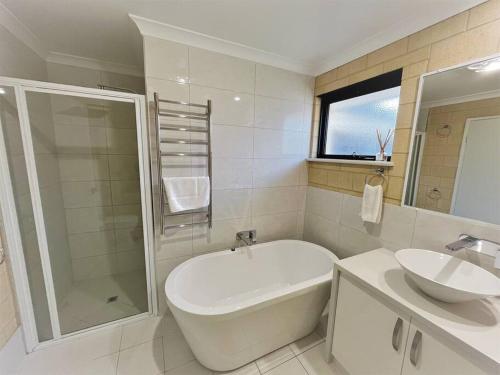 a bathroom with a tub and a sink and a shower at Sea Stays Esperance in Esperance