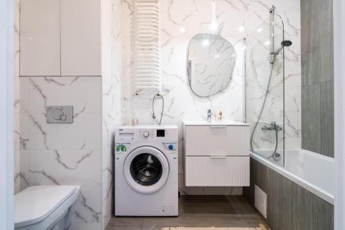 a white bathroom with a washing machine in it at ApartamentySnu, Wola Komfort II z parkingiem in Warsaw