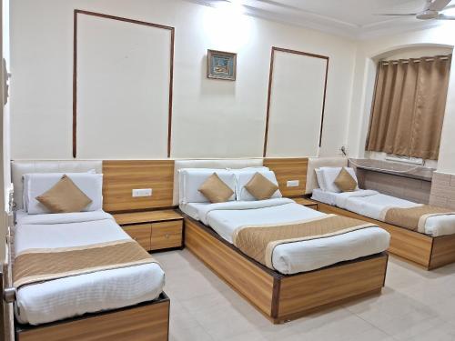 a bedroom with two beds and a sink at Swapna International in Mumbai