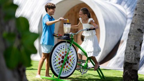 a boy and a girl with a blender on a bike at The Ritz-Carlton Maldives, Fari Islands in North Male Atoll