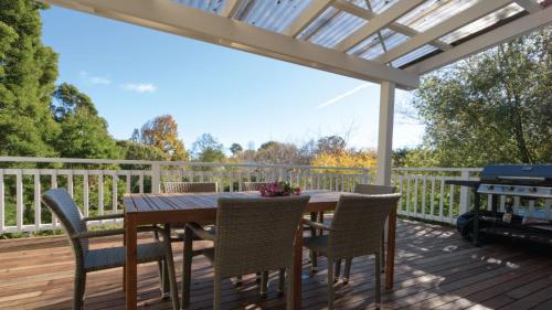 a wooden deck with a wooden table and chairs at Houlet House - Central Daylesford - Pets Welcome in Daylesford