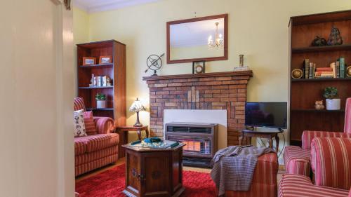 a living room with a fireplace and a tv at Houlet House - Central Daylesford - Pets Welcome in Daylesford