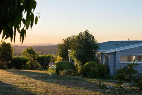 a house with the sun setting behind it at Musk Springs in Bullarto