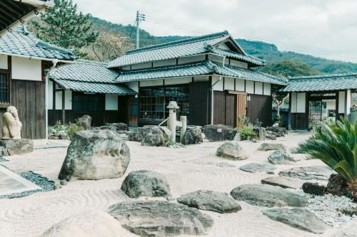 a temple with rocks in front of a building at Tokuto"Queen Villa" - Vacation STAY 81603v in Ieura