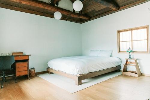 a bedroom with a bed and a desk and a window at Tokuto"Queen Villa" - Vacation STAY 81603v in Ieura