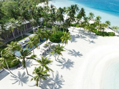 an aerial view of a resort on a beach with palm trees at The Ritz-Carlton Maldives, Fari Islands in North Male Atoll