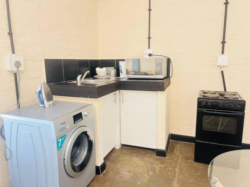 a kitchen with a washing machine and a microwave at Affordable Guest Room @260Main in Johannesburg