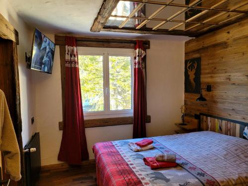 a bedroom with a bed and a window at Chalet le Chantelevent for 24 Guests - Slope Views, Pool & Jacuzzi in Vars