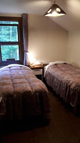 1 dormitorio con 2 camas y ventana en Bistare Kana, en Niseko