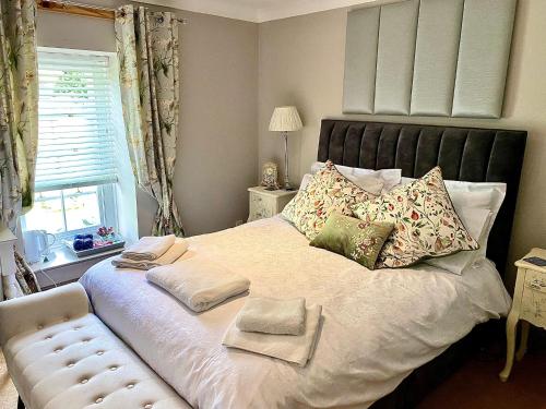 a bedroom with a large bed with pillows and a window at Bird In Bush Elsdon in Elsdon