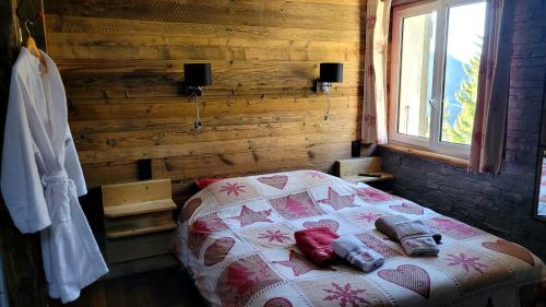 a bedroom with a bed in a wooden wall at Chalet le Chantelevent for 24 Guests - Slope Views, Pool & Jacuzzi in Vars