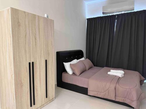 Schlafzimmer mit einem Bett und einem Holzschrank in der Unterkunft IKMICoreSoHo@KotaWarisanKLIA in Sepang