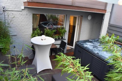 a patio with a white table and some plants at Suite 40 Jacuzzi & Sauna by Malmedreams in Malmedy