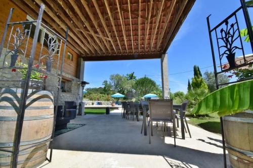 eine Terrasse mit einem Tisch und Stühlen sowie ein Gebäude in der Unterkunft Gite de groupe "L'Unisson" Domaine La Rose des Vents in Castelnau-sur-lʼAuvignon