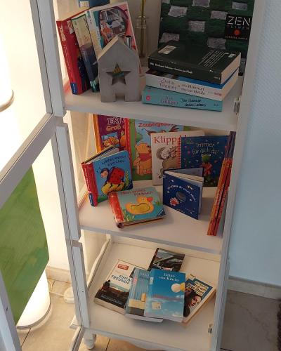 a book shelf filled with lots of books at Stadthotel am Bühnenhaus in Kevelaer