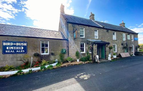 an old brick building with a sign on the side of it at Bird In Bush Elsdon in Elsdon