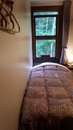 a bedroom with a bed and a window at Bistare Kana in Niseko