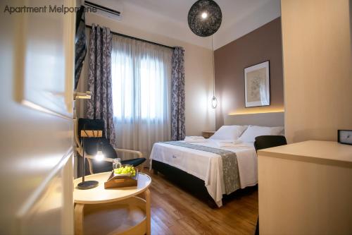 a small hotel room with a bed and a table at Polymnia & Melpomene by Heloni Apartments in Athens