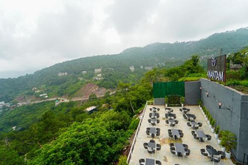 a group of tables and chairs on top of a building at Anantam Resort & Spa in Kasauli
