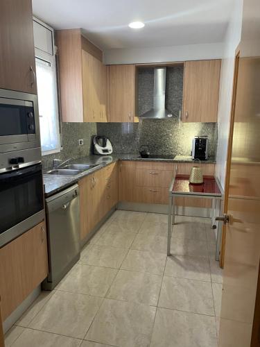 a kitchen with wooden cabinets and a table in it at Empordà Country House in Borrassá