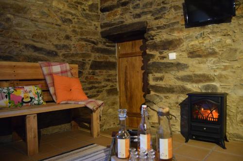 a room with a bench and a wood stove at Casas da Encosta in Proença-a-Nova