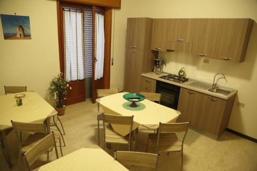 a kitchen and dining room with tables and chairs at Trapani Bedrooms in Trapani