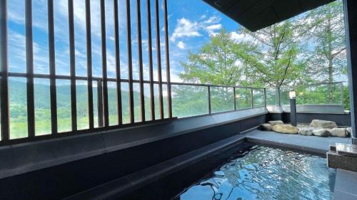 Una piscina de agua en una habitación con una gran ventana en Kurobe Sunvalley Hotel, en Omachi
