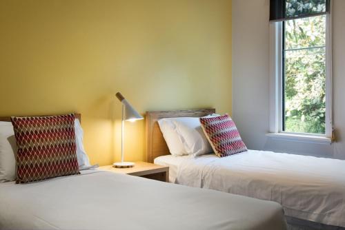 two beds in a room with two windows at Orford Panache in Daylesford