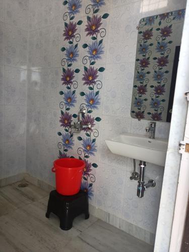 a bathroom with a sink and a red bucket at Aarambh Residency in Khajurāho