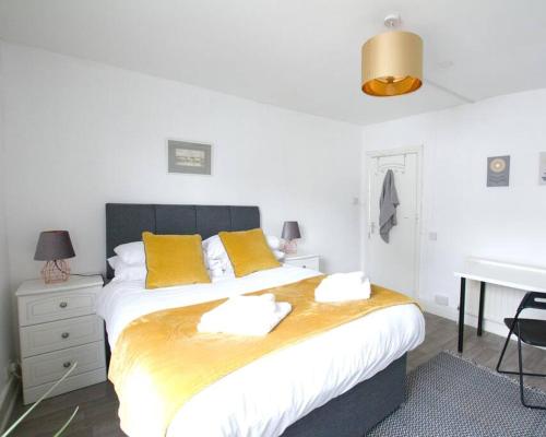 a bedroom with a bed with yellow pillows and a desk at City Centre 4 Bedroom-Sleeps 8! in Winchester