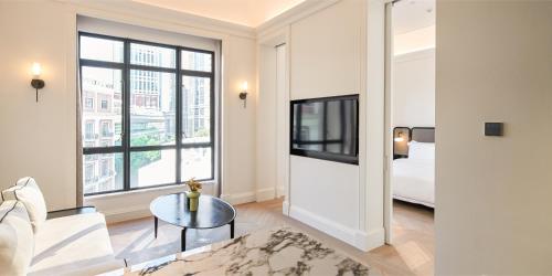 a living room with a couch and a tv and a bed at Opartment - People's Square 远东饭店 - 人民广场 in Shanghai