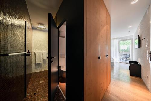 a bathroom with a toilet and a glass door at Soley Suites - adults only in Bressanone