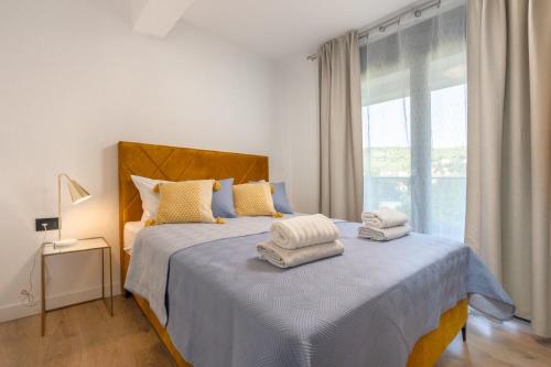 una camera da letto con un letto e asciugamani di Villa 64 Apartment #1 a Mlini