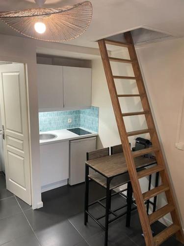 cocina con escalera, mesa y cocina en Le petit Championnet T2 en Grenoble
