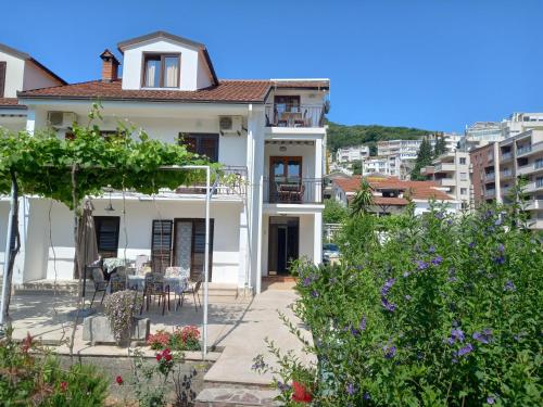 a white house with a garden in front of it at Apartments Budva Center in Budva