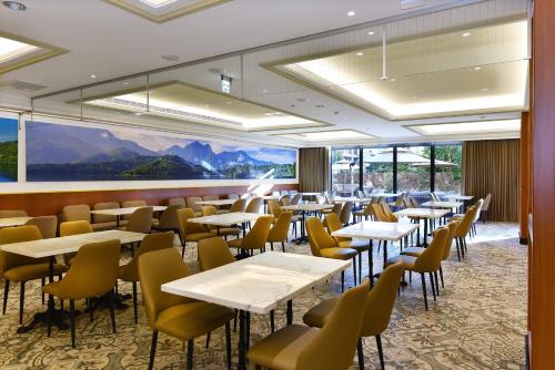 a restaurant with tables and chairs and a large window at Fullon Poshtel - Shuili in Shuili