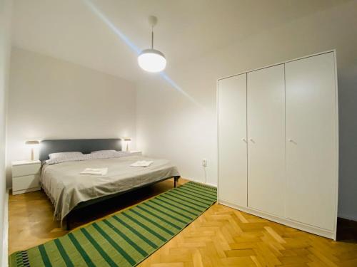 een slaapkamer met een bed en een groen tapijt bij Nono's apartament in Cluj-Napoca