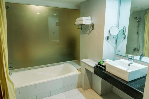 a bathroom with a sink and a bath tub and a sink at Best Western Heritage in Cox's Bazar