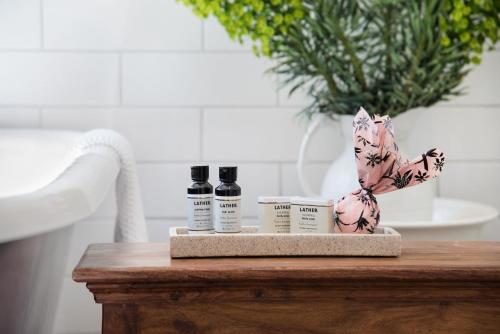 a table with two bottles of essential oils and a plant at Persimmon in Clunes