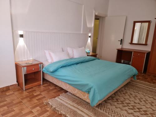 - une chambre avec un lit avec des draps bleus et 2 tables dans l'établissement Partial Nile View 2 Bedroom Appartment in Zamalek Cairo Newly Renovated, au Caire